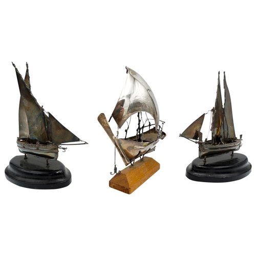 503 - THREE MINIATURE SILVERED-METAL MODEL SAILING BOATS20TH CENTURYraised on wooden bases. 14cm long appr... 