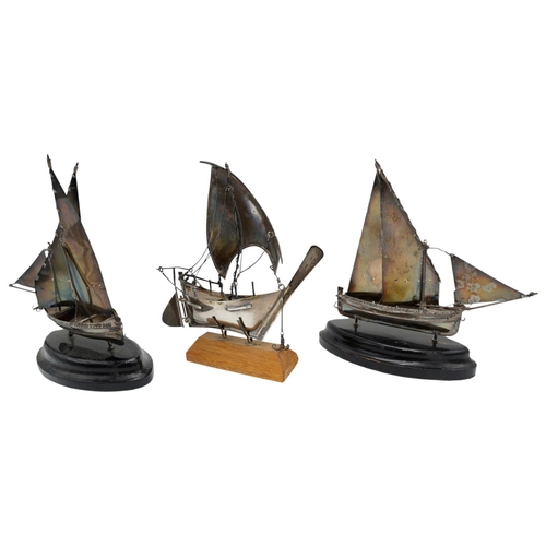 503 - THREE MINIATURE SILVERED-METAL MODEL SAILING BOATS20TH CENTURYraised on wooden bases. 14cm long appr... 