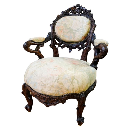 63 - CARVED BLACK FOREST LOW ARMCHAIR19TH CENTURYof naturalistic form, with a padded back, arms and stuff... 