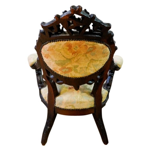 63 - CARVED BLACK FOREST LOW ARMCHAIR19TH CENTURYof naturalistic form, with a padded back, arms and stuff... 