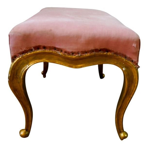 74 - LOUIS XV STYLE GILTWOOD STOOL19TH CENTURYthe serpentine padded seat covered in pink fabric, raised o... 