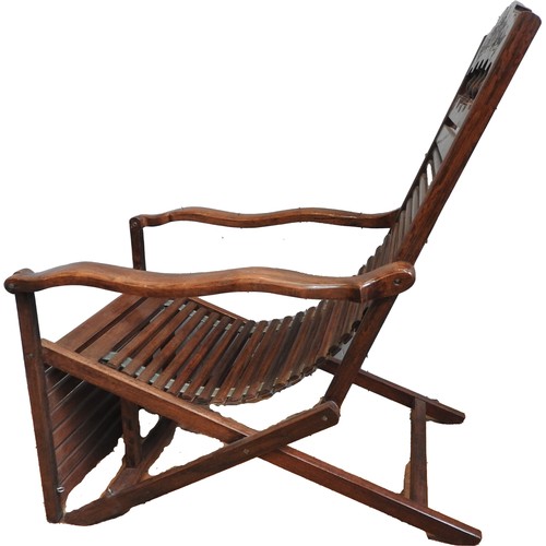 76 - INDIAN HARDWOOD LOLLING CHAIR20TH CENTURYwith slatted seat  and back panel, shaped open arms and a f... 