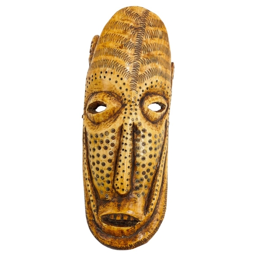 404 - AN AFRICAN IVORY TRIBAL MASK FROM ZAIRE, late 19th century, decorated with drilled roundels and zig-... 