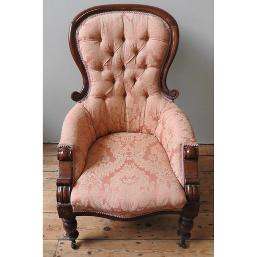 54 - A VICTORIAN MAHOGANY NURSING CHAIR, with scroll carved spoon back, buttoned upholstery supported by ... 