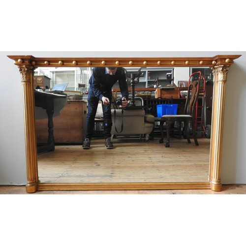 268 - A REGENCY STYLE GILT OVERMANTEL MIRROR, with ball frieze flanked by Corinthian columns. 128 x 84cms