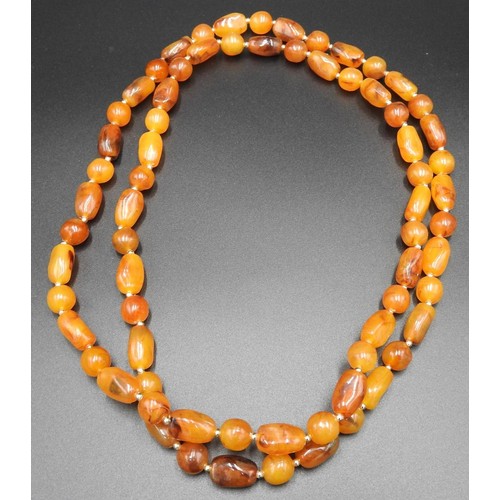 587 - AN AMBER BEAD NECKLACE, with naturalistic form beads, 58 cm long