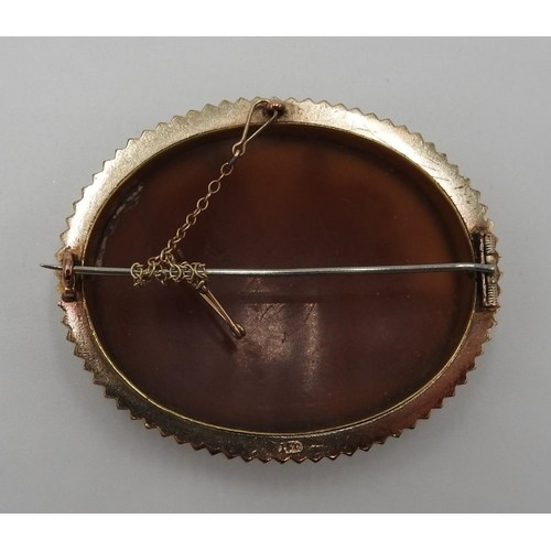 590 - A 15 CT GOLD OVAL CAMEO BROOCH, the carved decoration depicting Roman soldiers, 5.5cm wide