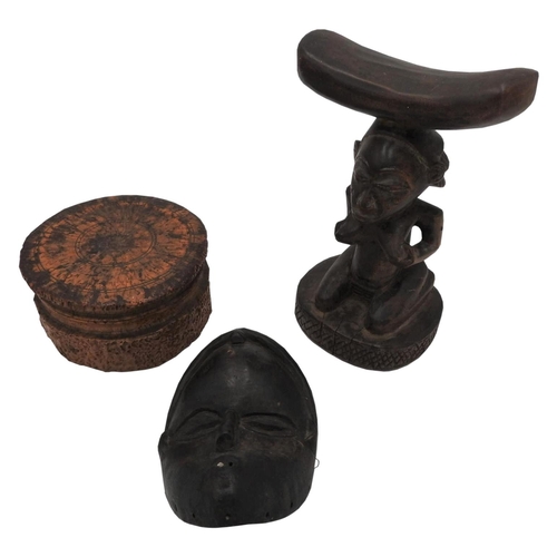 257 - A CARVED TREEN TRIBAL HEAD REST, CARVED WOODEN MASK AND A COVERED SOFT WOOD BOX, the head rest decor... 