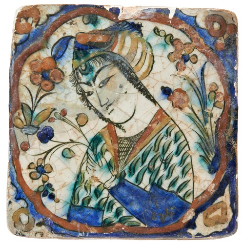 347 - SAFAVID GLAZED POTTERY TILE17TH CENTURYdepicting a young man holding a flower, in an old wooden coll... 