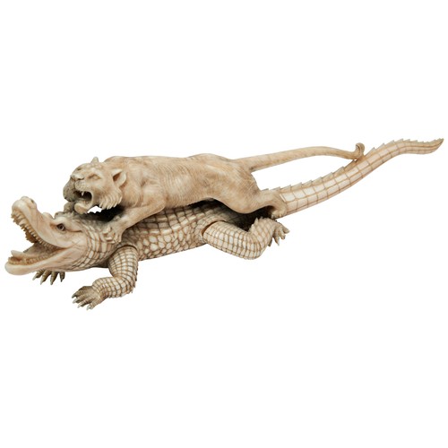 337 - A JAPANESE 19TH CENTURY IVORY OKIMONO OF A LION ATTACKING A CROCODILE, the lioness grasping its back... 