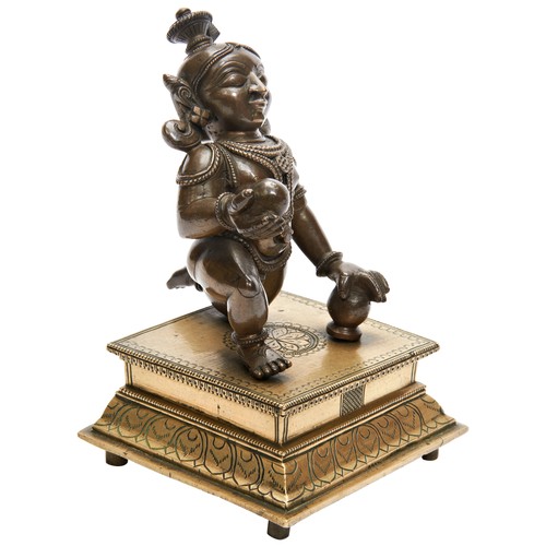 357 - BRONZE FIGURE OF AN INFANT KRISHNAINDIA, 19TH CENTURYthe figure shown kneeling, raised on a stepped ... 