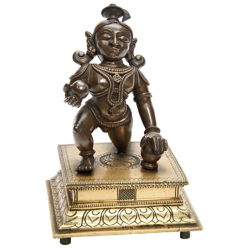 357 - BRONZE FIGURE OF AN INFANT KRISHNAINDIA, 19TH CENTURYthe figure shown kneeling, raised on a stepped ... 