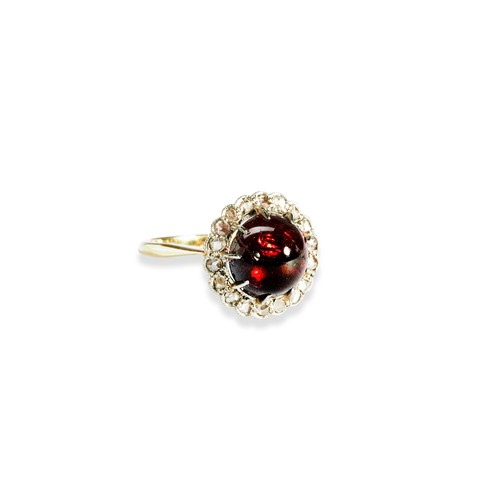 122 - GARNET AND ROSE CUT DIAMOND RINGset with a large claw set garnet cabochon surrounded by a halo or sm... 