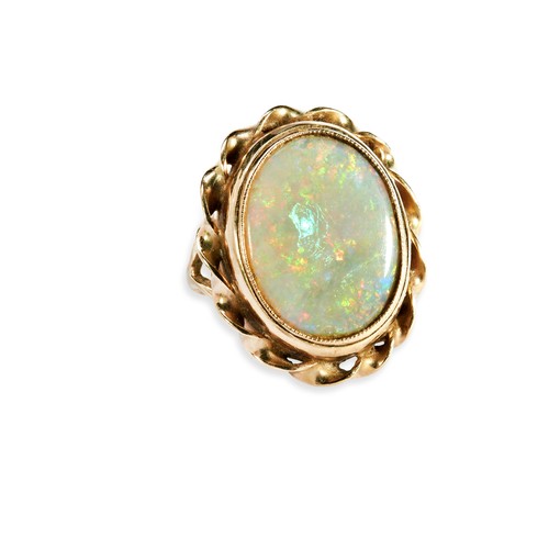 120 - AN OPAL RING the oval cabochon-cut opal set within a twisted border and split shank. Ring size I. Un... 