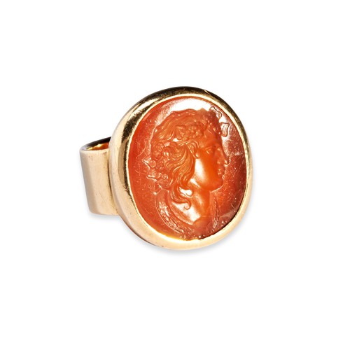 139 - A CARNELIAN AND GOLD RING, CIRCA 1800-1850  the oval carnelian intaglio of a bacchante, within a hea... 