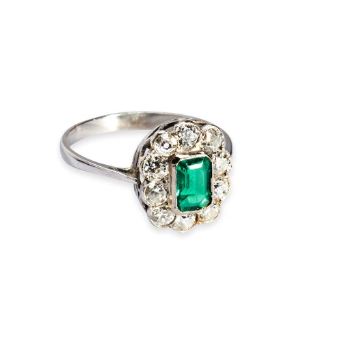 4 - AN EMERALD AND DIAMOND CLUSTER RING, CIRCA 1900 the step-cut emerald, collet set within a border of ... 