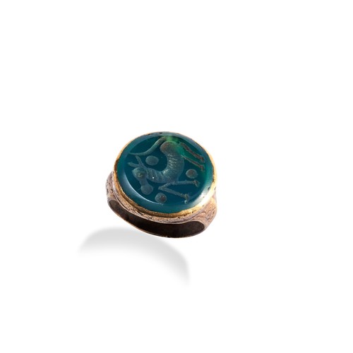 137 - AN INTAGLIO RING, the green Sasanian style seal stone cut with a stylised horse, in a polished bronz... 