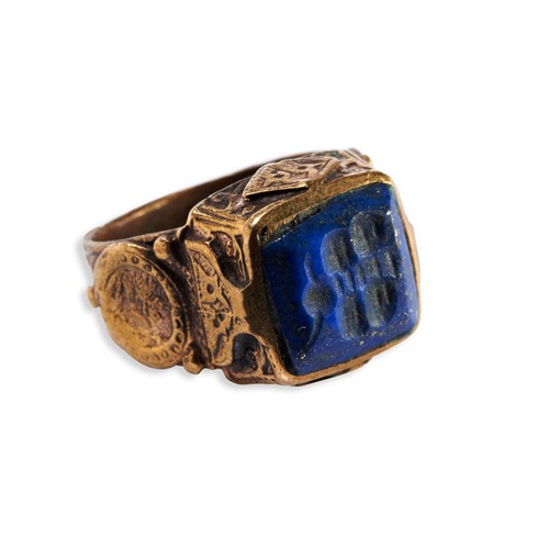 136 - A PERSIAN/BYZANTINE POLISHED BRONZE RING, the raised square top inset with a lapis stone engraved wi... 