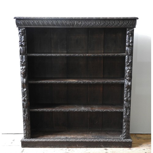 17 - AN ORNATE CARVED OAK 19TH CENTURY BOOKCASE, with three adjustable shelves, a central lobe carved fri... 