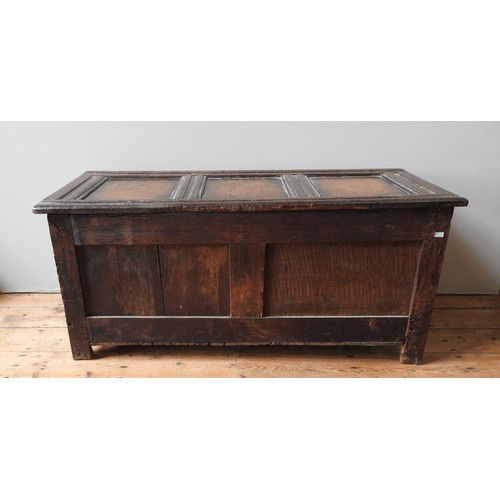 33 - AN EARLY 18TH CENTURY OAK COFFER, the triple panel front and top rail carved with floral roundel dec... 