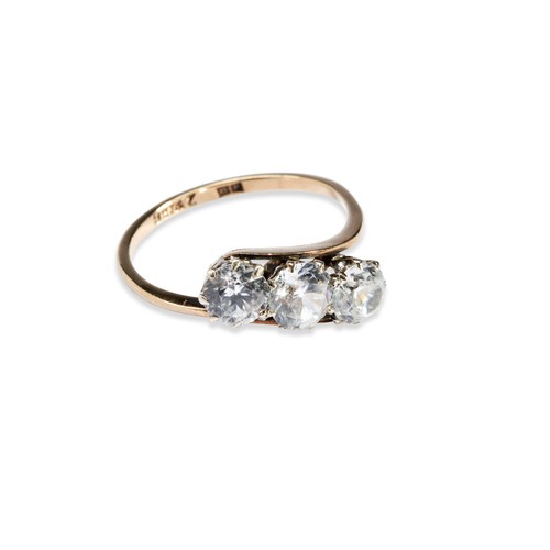 528 - A 9CT GOLD CROSSOVER DRESS RING SET WITH THREE STONES, probably cubic zirconia, the ring stamped 9ct... 