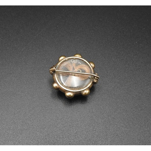 529 - A VINTAGE CIRCULAR MOURNING BROOCH, with convex glass front and lock of hair contained within, 2.5 c... 