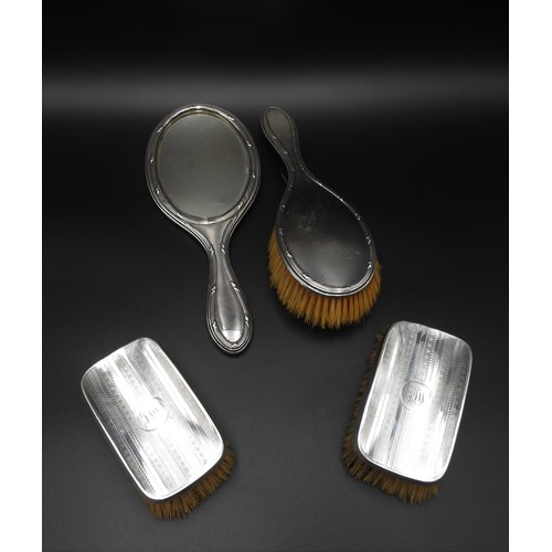 451 - A VINTAGE SILVER HAND MIRROR, MATCHING BRUSH AND TWO OTHER SILVER BRUSHES,