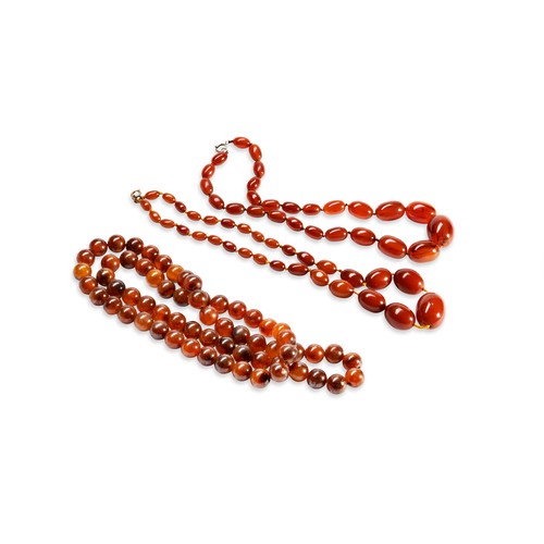 531 - A QUANTITY OF NECKLACESTwo dark orange graduating beaded bakelite necklaces. Together with three ora... 