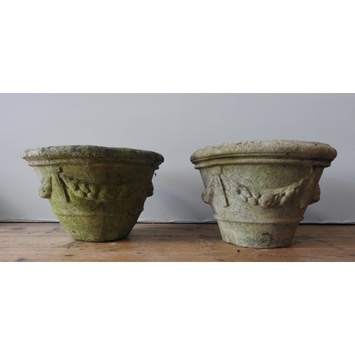 143 - A PAIR OF WEATHERED RECONSTITUTED STONE TAPERED GARDEN PLANTERS, with swag decoration, 36 cm high an... 