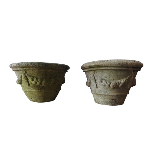 143 - A PAIR OF WEATHERED RECONSTITUTED STONE TAPERED GARDEN PLANTERS, with swag decoration, 36 cm high an... 