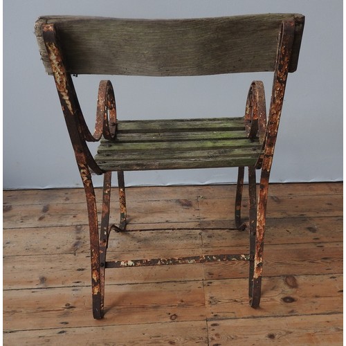 147 - A WROUGHT-IRON WOODEN SLATTED WEATHERED GARDEN ARMCHAIR, with curved seat, back panel and scroll arm... 