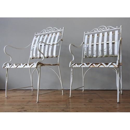 148 - A FRENCH CREAM PAINTED WROUGHT-IRON GARDEN BENCH SEAT AND TWO MATCHING ARMCHAIRS, all with lattice w... 