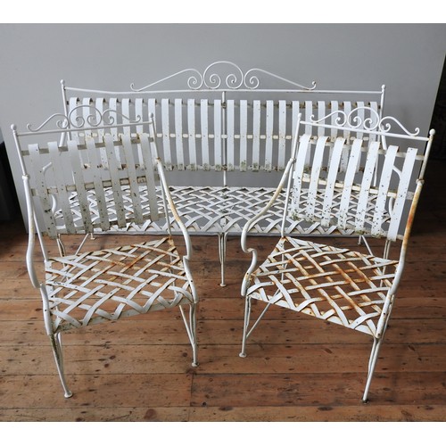 148 - A FRENCH CREAM PAINTED WROUGHT-IRON GARDEN BENCH SEAT AND TWO MATCHING ARMCHAIRS, all with lattice w... 