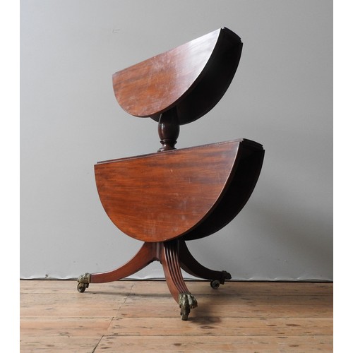 57 - AN EDWARDIAN MAHOGANY REGENCY STYLE DUMB WAITER, two graduated drop-leaf circular table tops united ... 