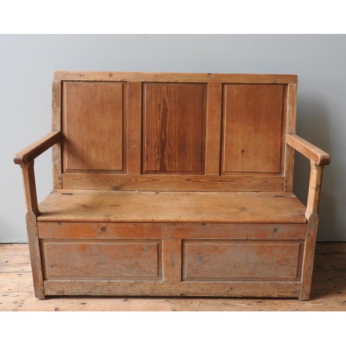 72 - A 19TH CENTURY PINE SETTLE, with three panel back, lift-top seat and open rail arms, 106 x 132 x 45 ... 