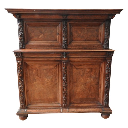 76 - A 18TH CENTURY AUSTRIAN WALNUT SHRANK,  in two sections, with parquetry door panels, long frieze dra... 