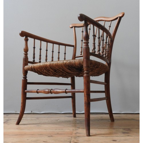 79 - A 19TH CENTURY RUSH SEAT ELBOW CHAIR, with a serpentine top rail supported by turned spindles, on fo... 