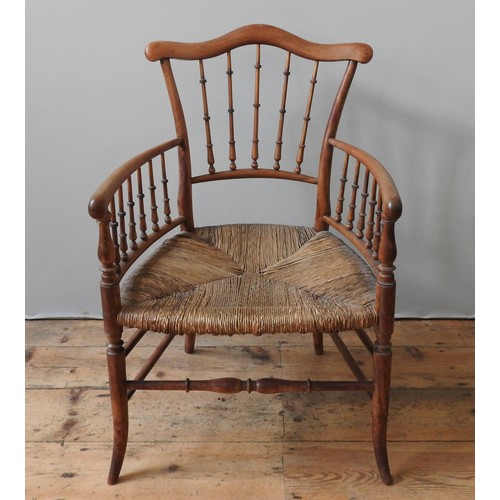 79 - A 19TH CENTURY RUSH SEAT ELBOW CHAIR, with a serpentine top rail supported by turned spindles, on fo... 