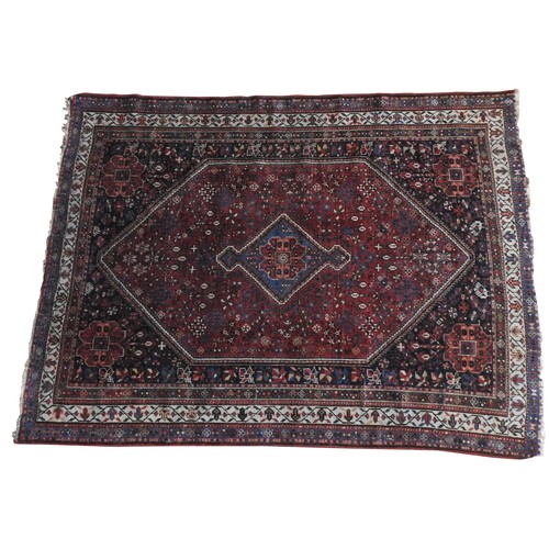 84 - A PERSIAN QASHQAI HAND KNOTTED MEDALLION PATTERN RUG, with a floral border pattern on a deep blue gr... 