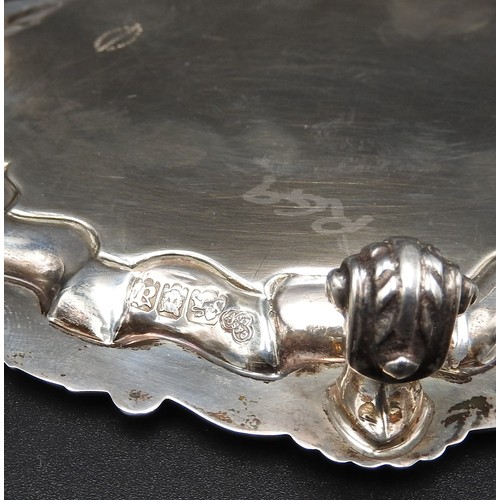 464 - A SILVER SALVER, with acanthus shell-scroll border on three scroll feet, London 1916, maker's mark G... 