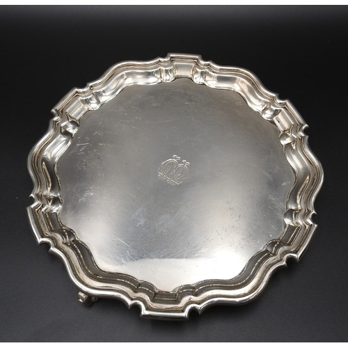 466 - A SILVER SALVER, with scroll work edge, on three scroll feet, London 1911, maker's stamp H & A.S... 