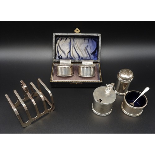 473 - A SILVER CRUET SET, SILVER TOAST RACK AND A PAIR OF SILVER NAPKIN RINGS, circa 1920 and 1940, the to... 