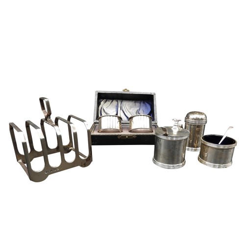 473 - A SILVER CRUET SET, SILVER TOAST RACK AND A PAIR OF SILVER NAPKIN RINGS, circa 1920 and 1940, the to... 