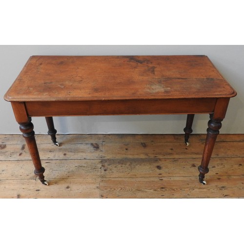 130 - A VICTORIAN MAHOGANY SIDE TABLE, on four turned baluster legs, terminating in brass cups and casters... 