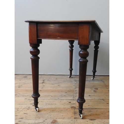 130 - A VICTORIAN MAHOGANY SIDE TABLE, on four turned baluster legs, terminating in brass cups and casters... 