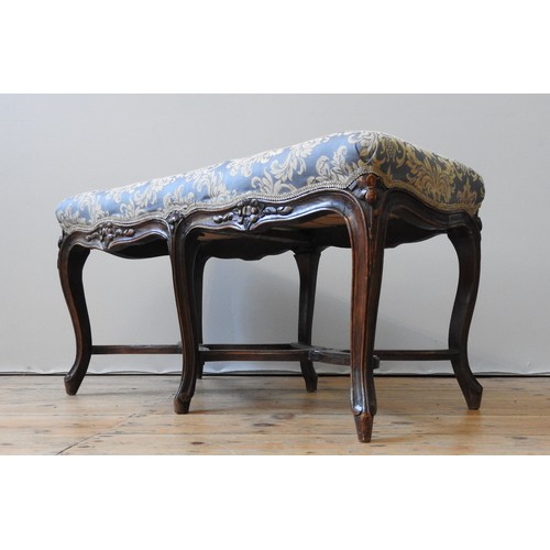 133 - A 19TH CENTURY FRENCH OAK STOOL , the upholstered seat supported by six cabriole legs, united by sha... 