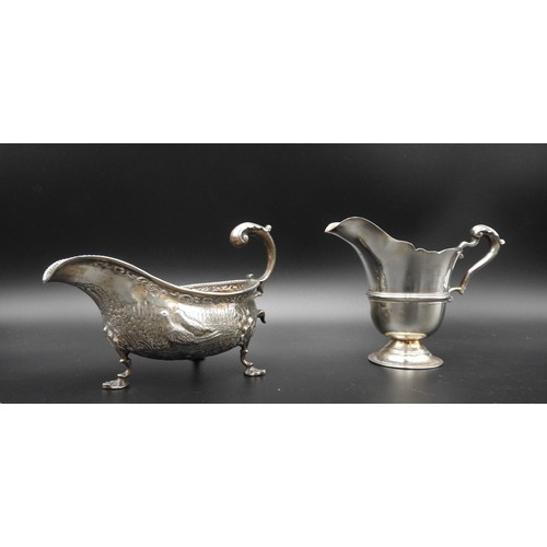 475 - AN IRISH SILVER MILK JUG AND A SILVER SAUCEBOAT, the Irish jug is Dublin 1917, stamped with a maker'... 