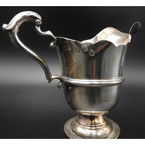 475 - AN IRISH SILVER MILK JUG AND A SILVER SAUCEBOAT, the Irish jug is Dublin 1917, stamped with a maker'... 