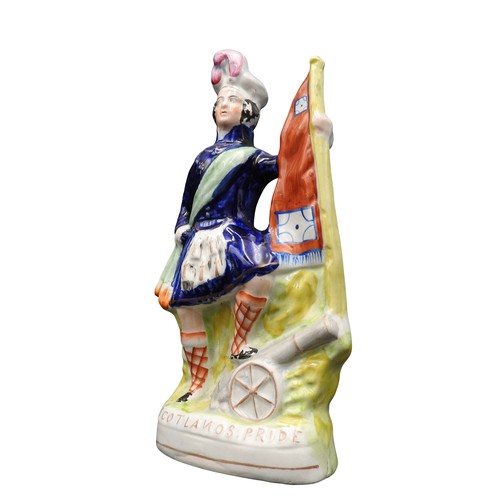 417 - 'SCOTLANDS PRIDE' A VICTORIAN STAFFORDSHIRE FIGURE DEPICTING A SCOTTISH SOLDIER WITH CANNON AND FLAG... 