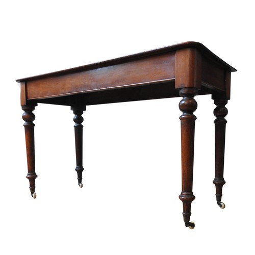 130 - A VICTORIAN MAHOGANY SIDE TABLE, on four turned baluster legs, terminating in brass cups and casters... 